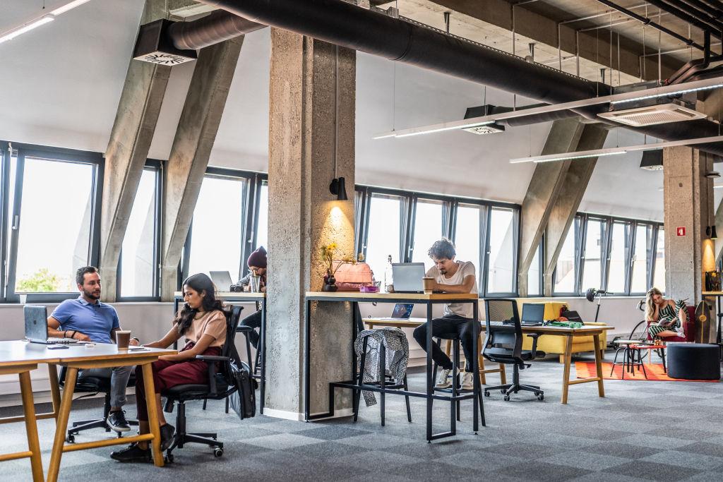 Group of entrepreneurs working in their own open space loft apartment office.
