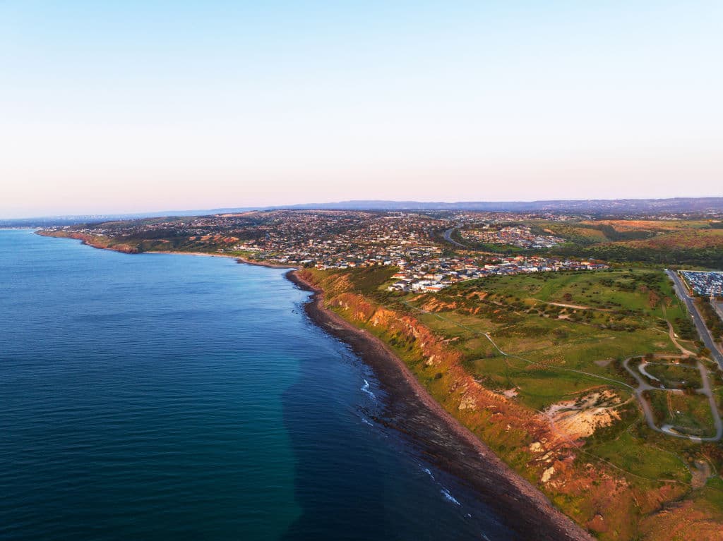 The dark blue sea meets the rugged coastline of Hallett Cove.