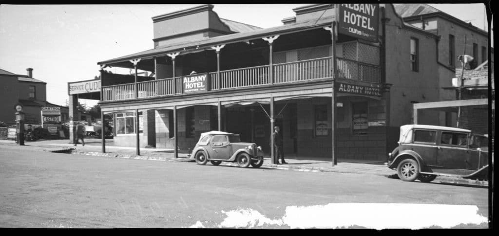 A black and white image of a two storey hotel with a car parked out the front from 1937.