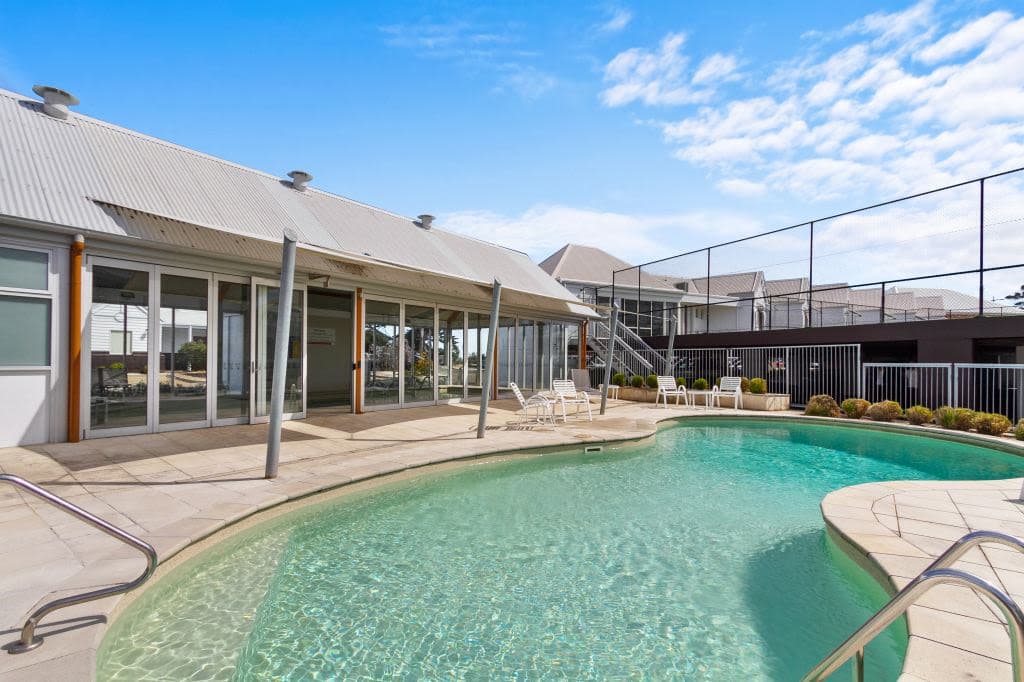 An outside pool next to buildings.