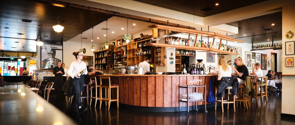 A bar with people serving