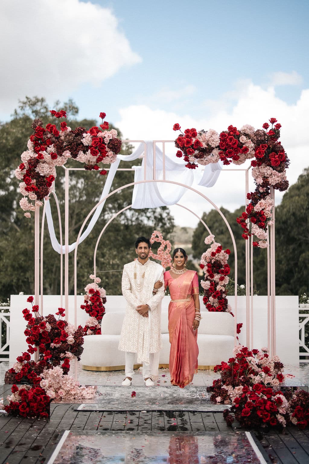 A couple pause beneath a glorious mandap - traditional in Hindu and Jain weddings - at Bramleigh Estate.