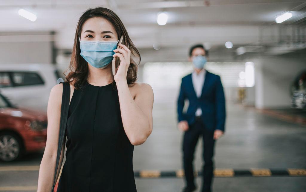 an asian chinese beautiful woman and handsome man looking at camera smiling with their face mask surgical mask on