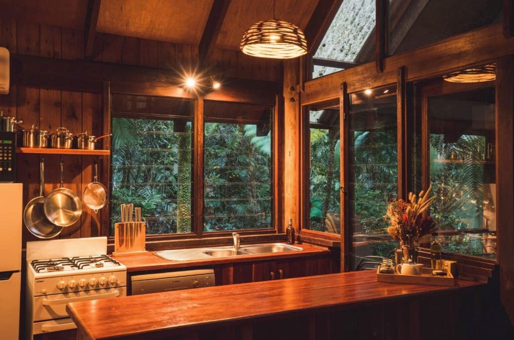 A timber kitchen with a high roof, and pleasant lighting.