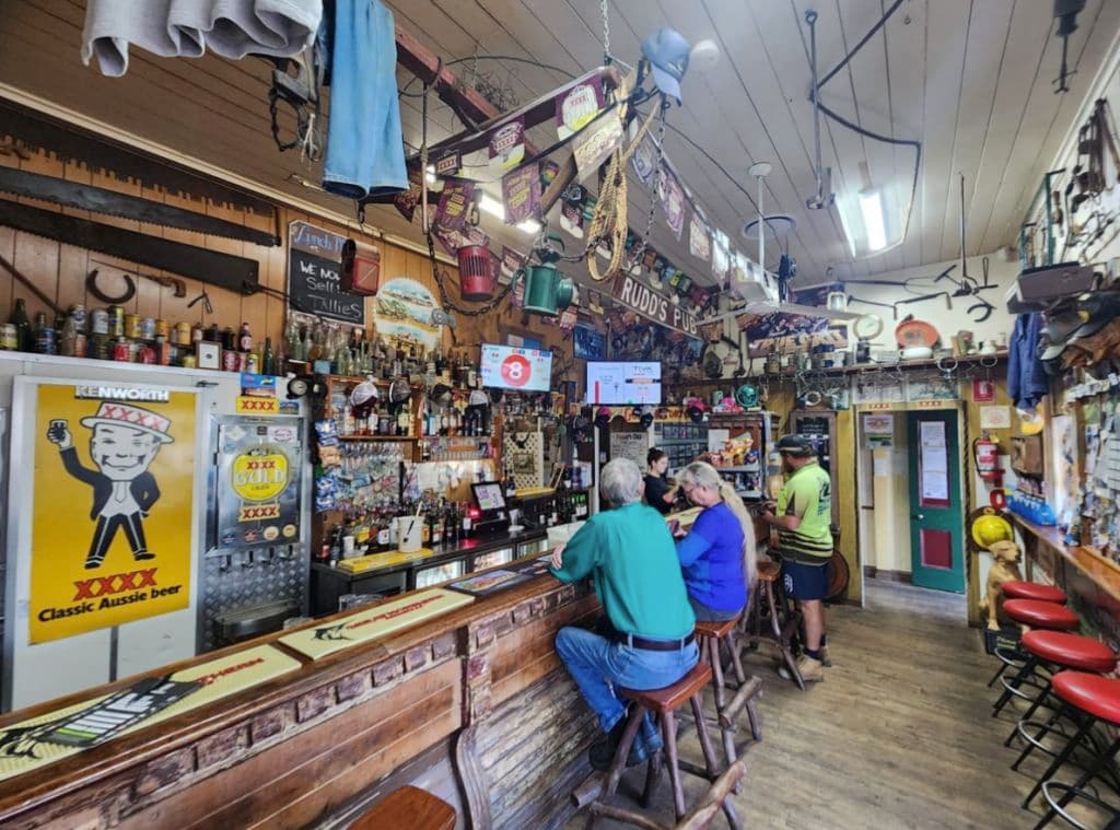 Several patrons sit at the bar adorned with historic farming items.