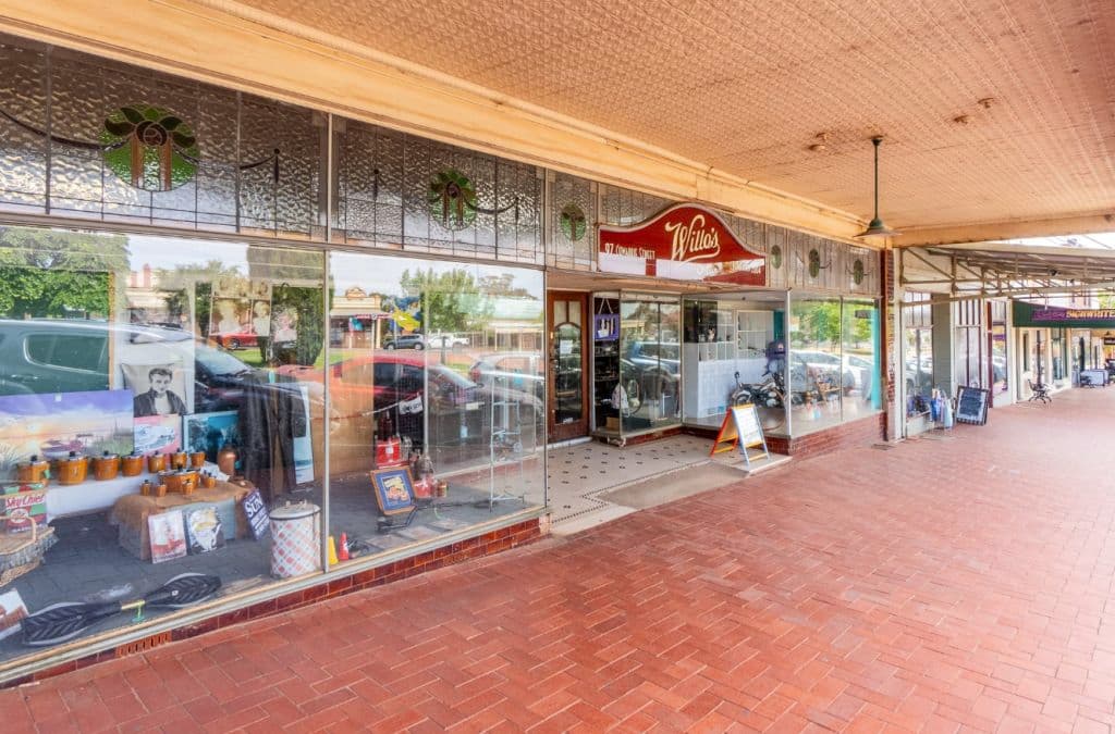 The exterior of the building is seen with large glass windows and leadlight components.