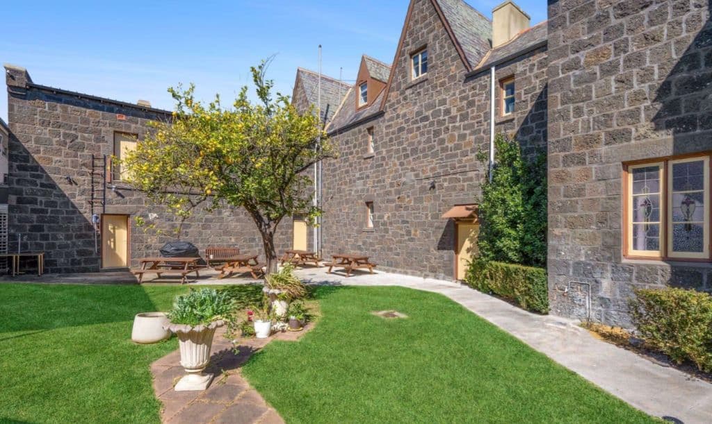 An outside space with a tree and grass and heritage exterior.