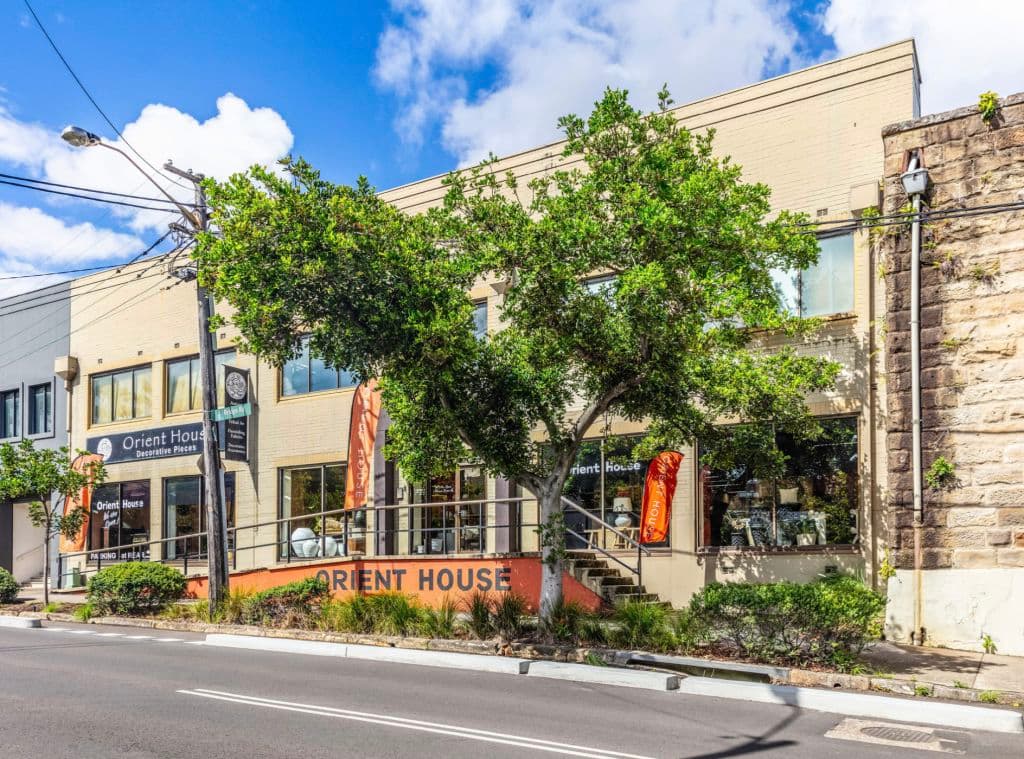 A tree stands out of the front of the cream-coloured exterior.