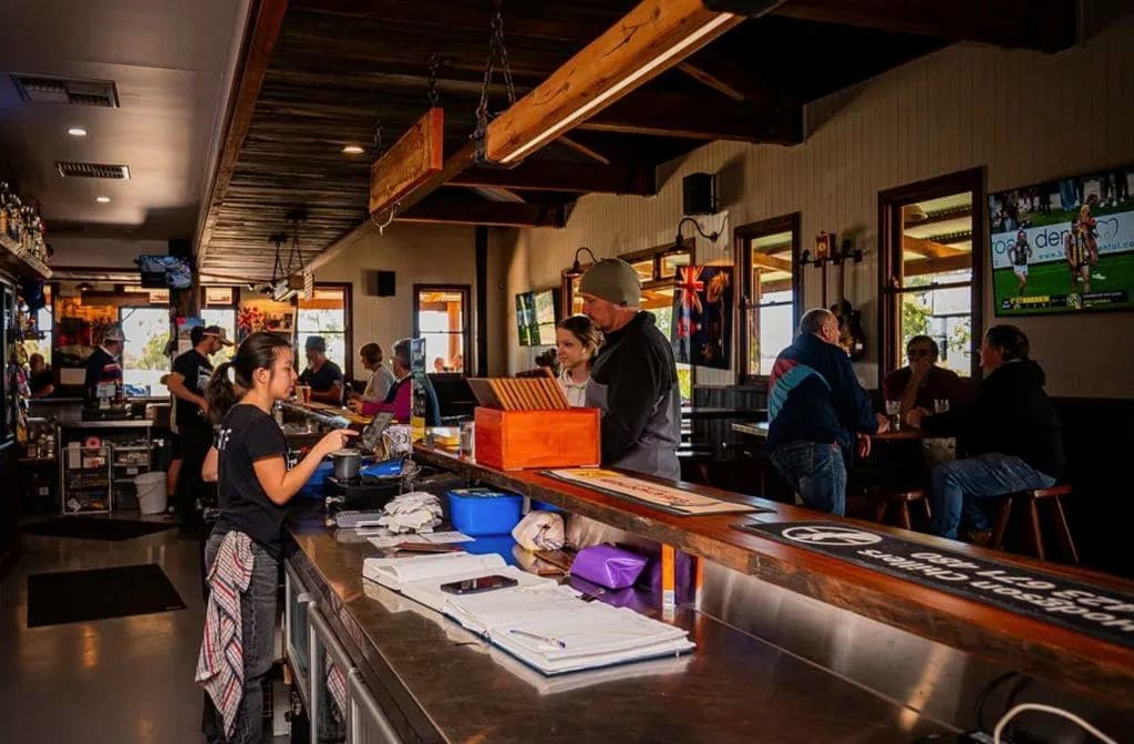 The inside of the pub shows a long bar with timber beam features overhead.