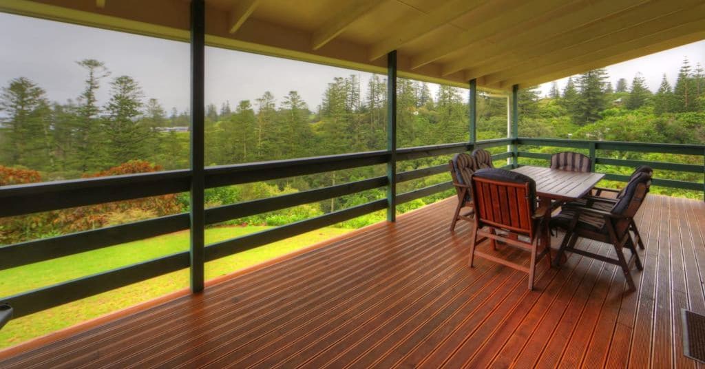 A large covered timber deck with furniture on it.