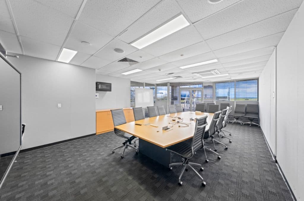 An office space with a large boardroom table and chairs around it.