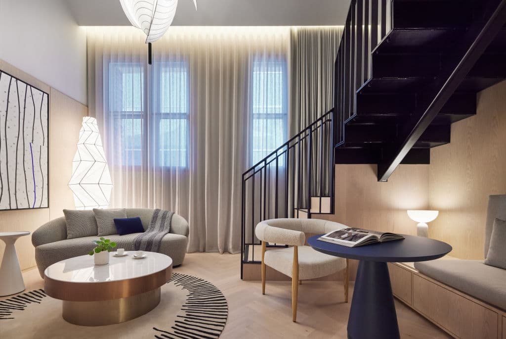 Lanson PLace heritage loft room with table and chair and stairs to mezzanine level