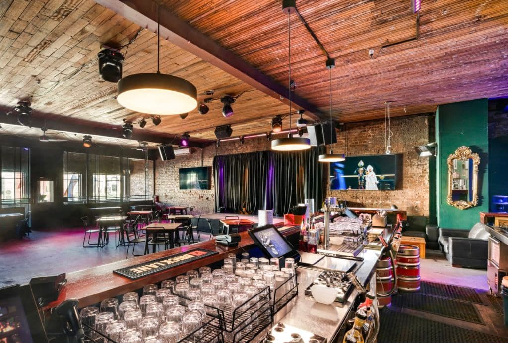 Glasses are stacked on the top of a bar.