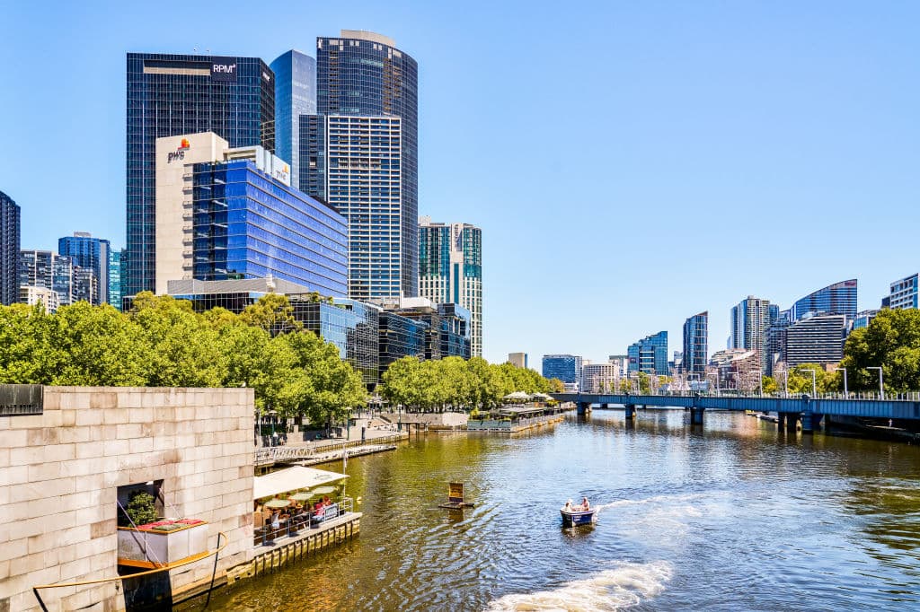 A view of the Yarra River and the PwC building on the left side among other buildings.