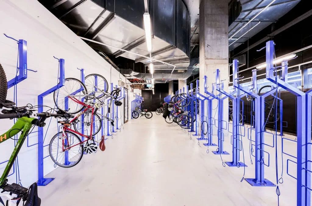 Bikes hang on a modern bike rack at the office tower.
