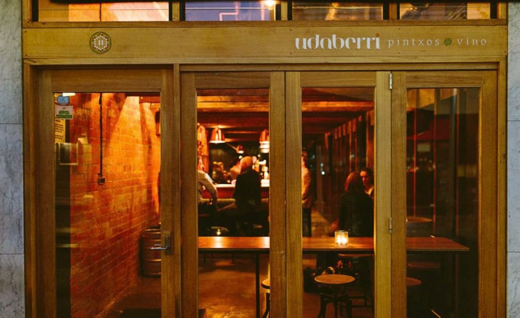 The glass front doors of the narrow bar which has its name across it