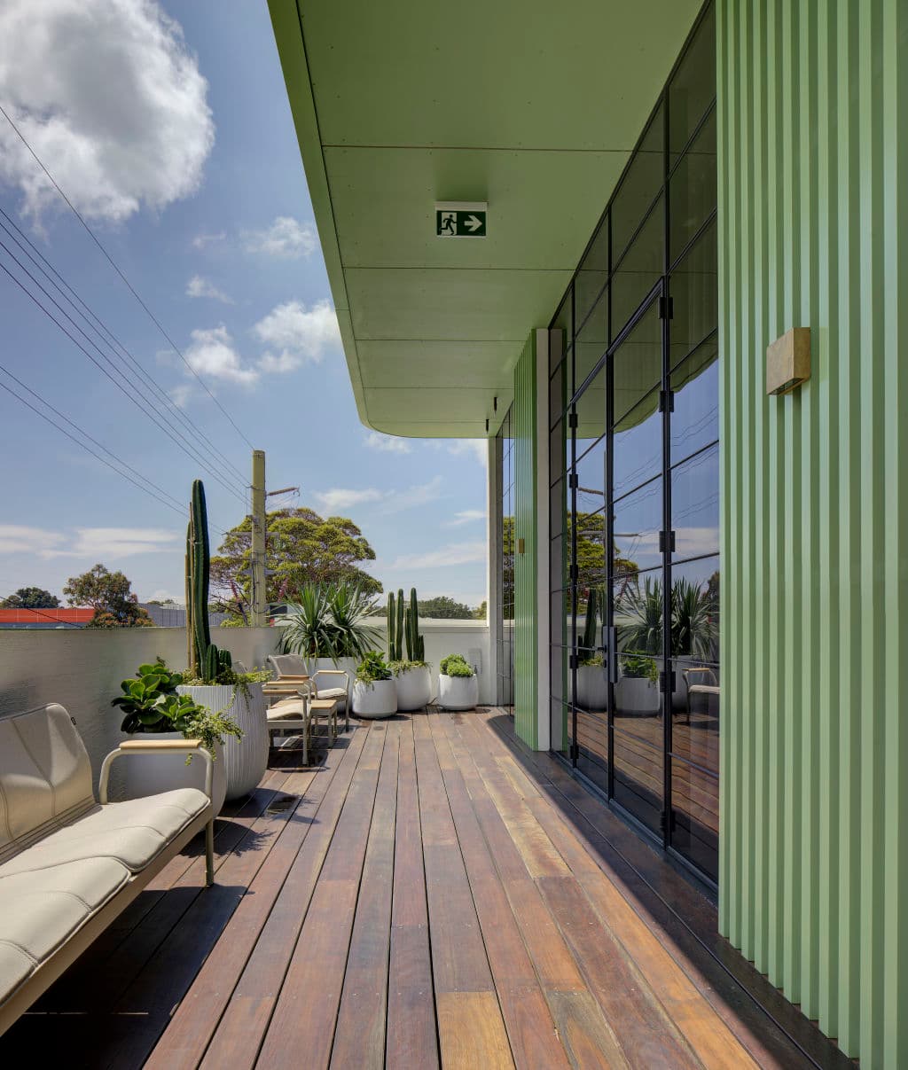 The balcony of a gym with plants and seating