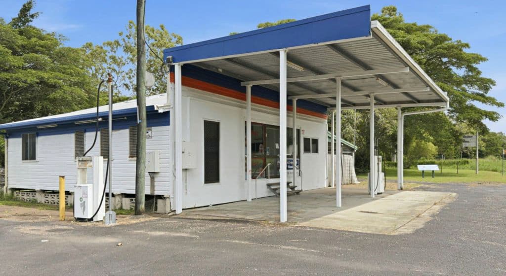 The petrol station building remains with a covered area and most pumps removed.