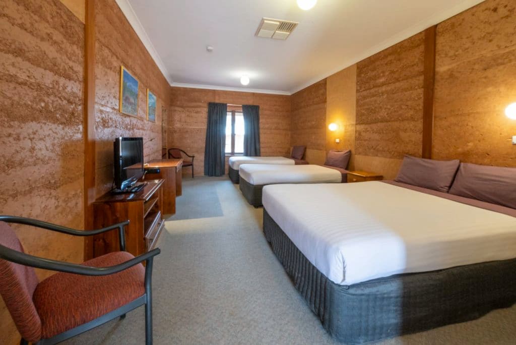 Three sets of beds in a long room.