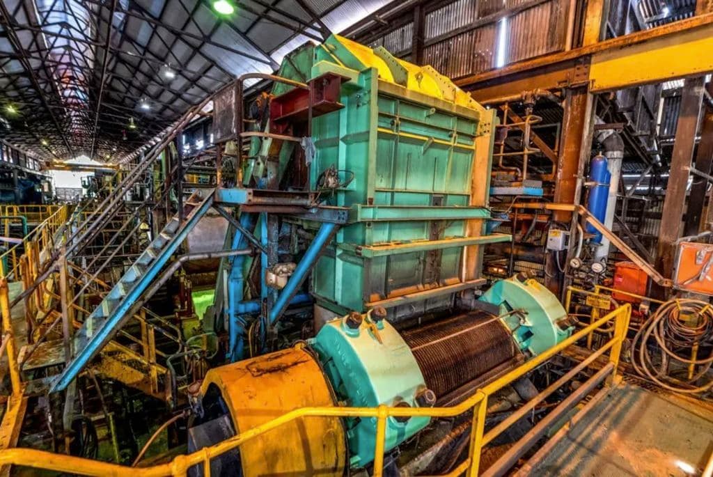 a machine in the mill building is green and yellow inside a factory.