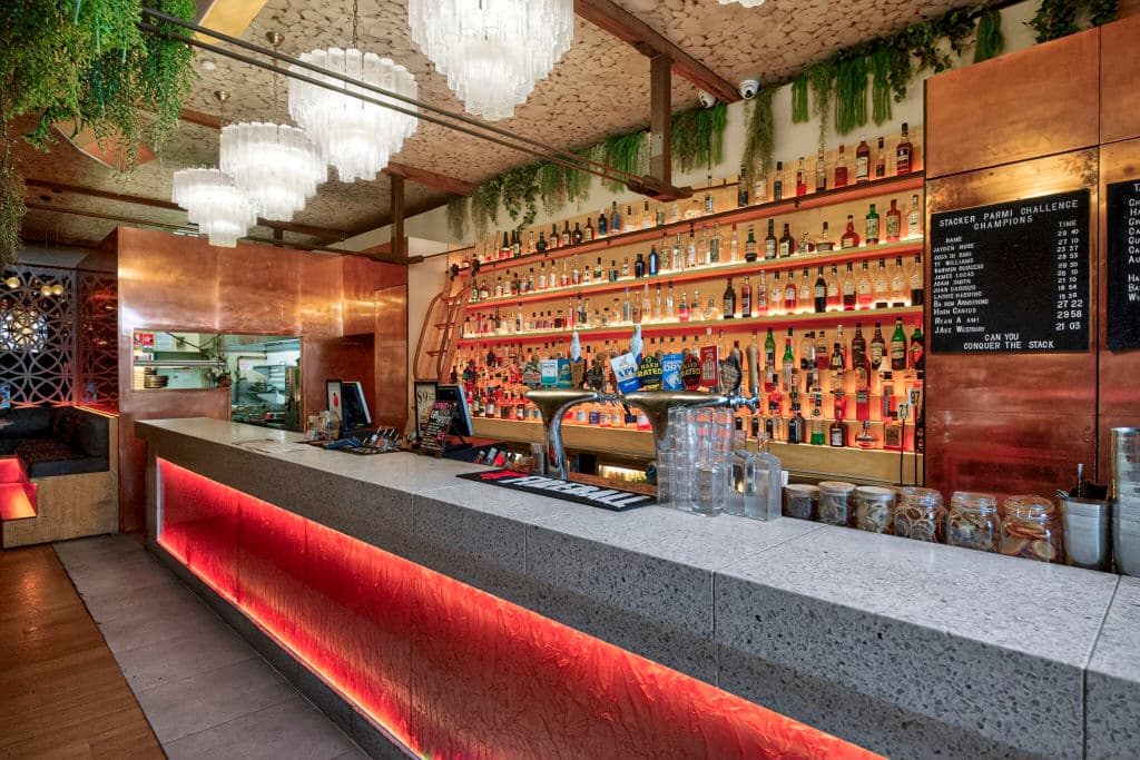 A bar with red lighting on the public side.