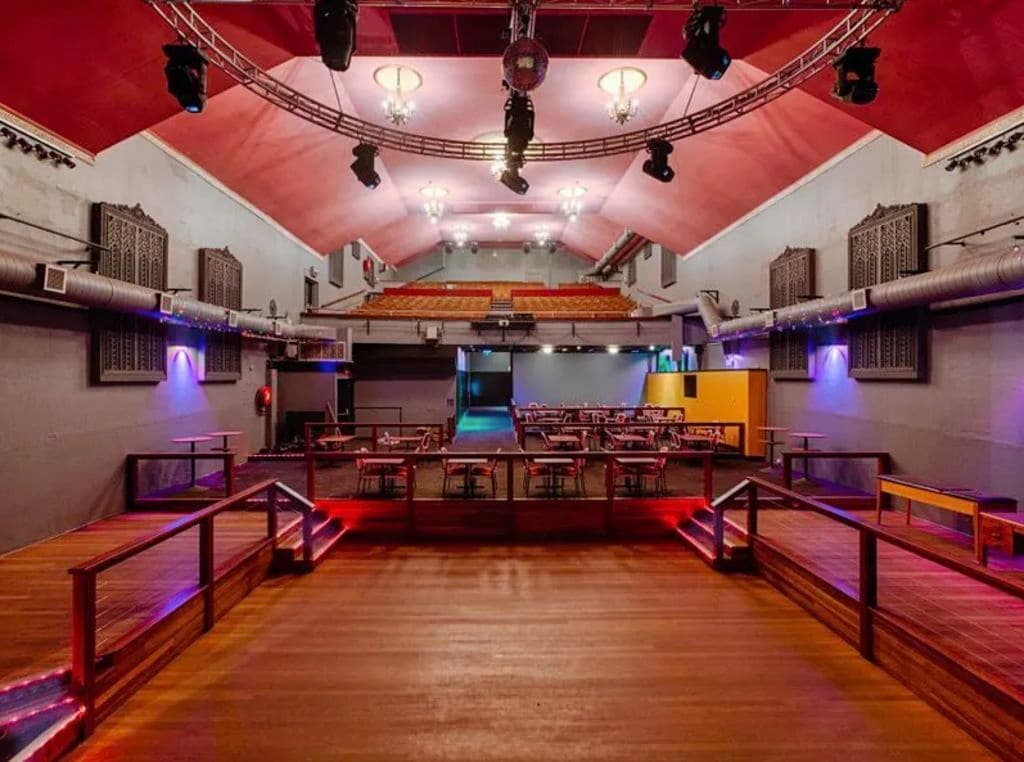 Timber floors and stage lighting are shown in a large space.