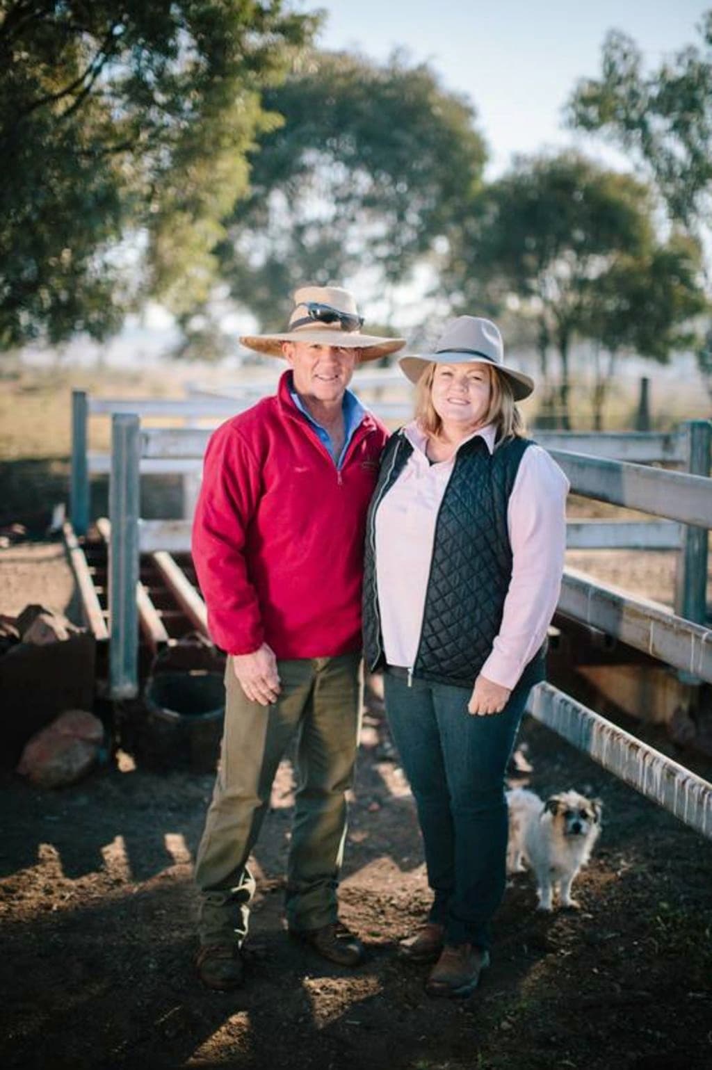 A man in a red jumper with a har and a woman in a pink shirt and hat.