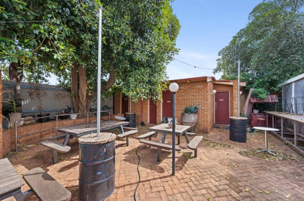 A courtyard with red bricks on the ground and tables set up.