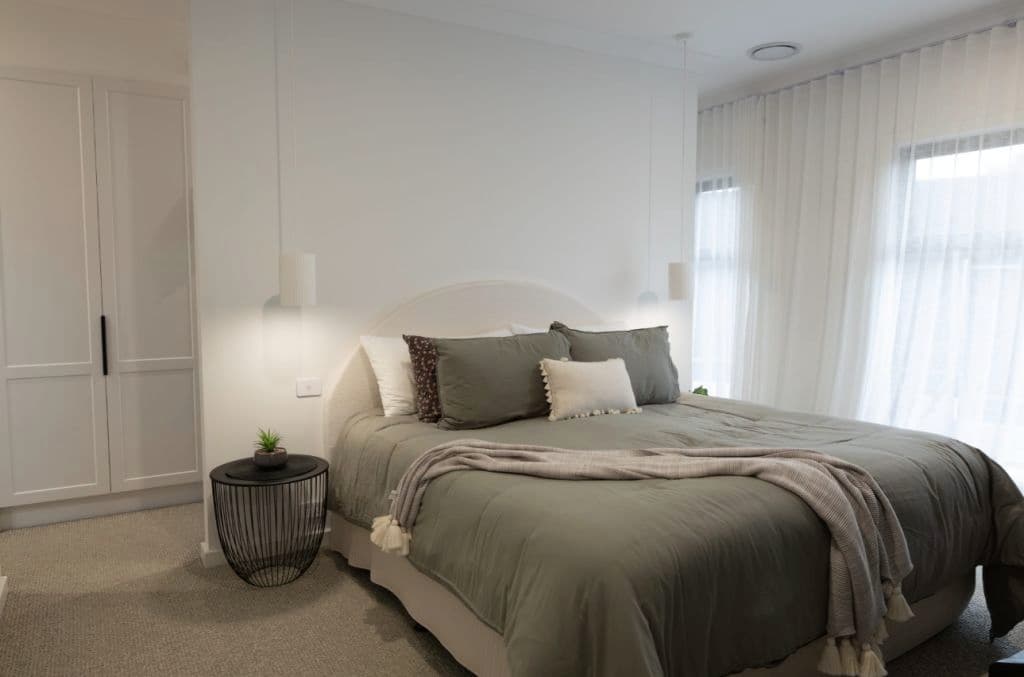 A modern bedroom with a large bed and modern lighting.
