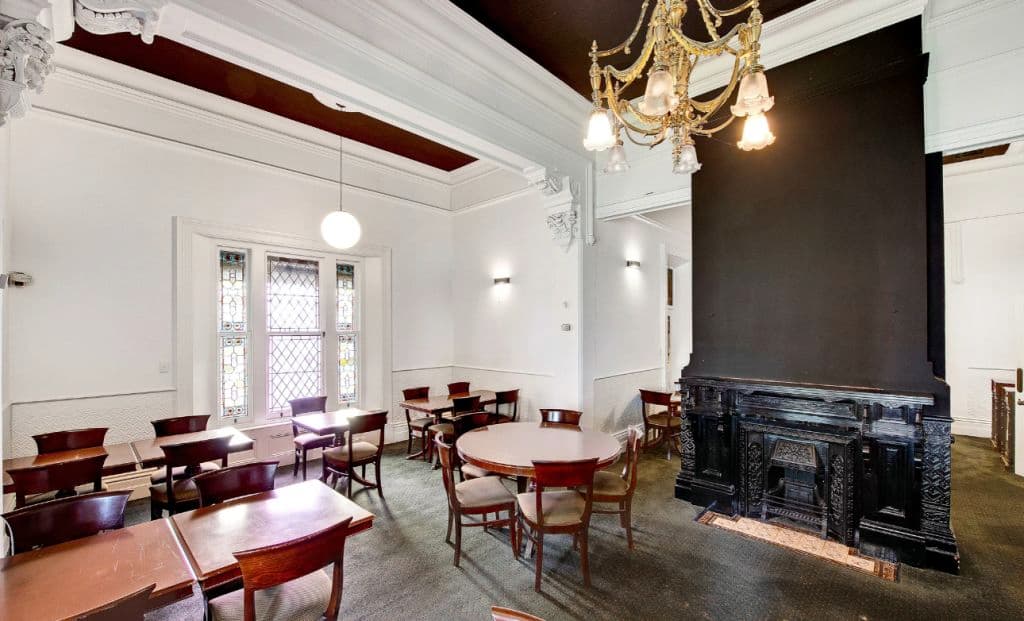 The dining room has tables and chairs and chandeleirs.