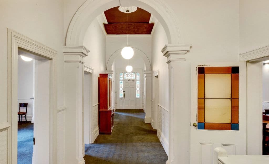a hallway with historic details seen in glass and curves of the arched hallway.