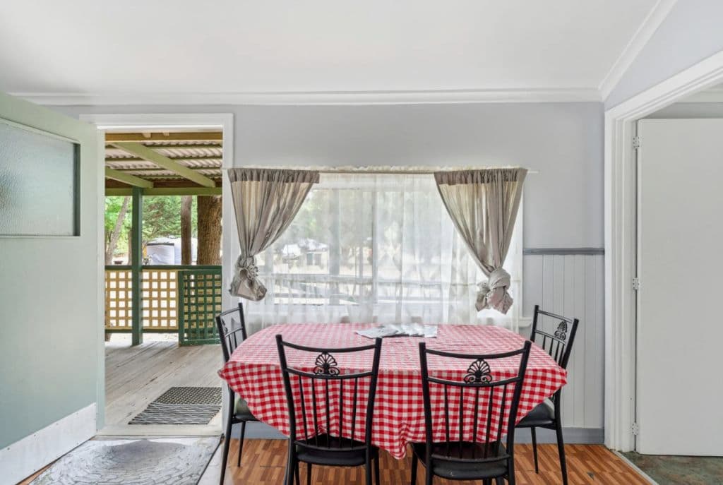 A cute old fashioned kitchen table in a small room.
