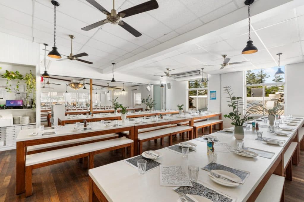 Inside of a restaurant with set tables.