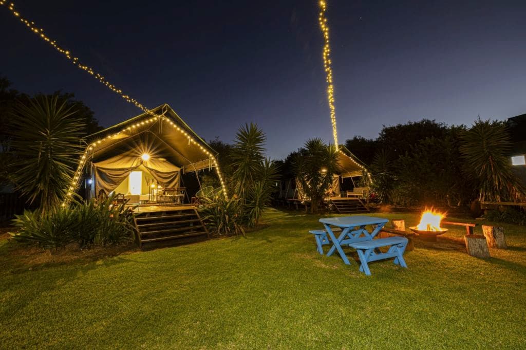 A view of lit up tents with lights at night.