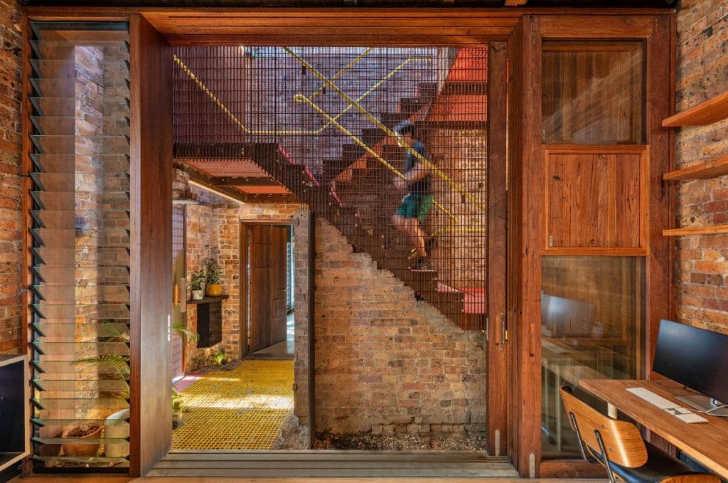 A modern staircase design shows exposed brick and timber frames.