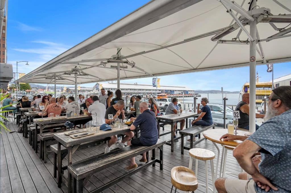 A seated space overlooking water with overhead protection from the weather.