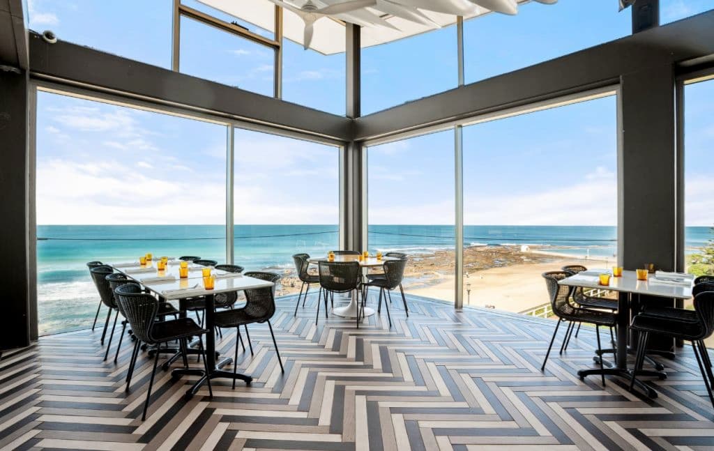 Diners enjoy panoramic views across the stunning ocean from sophisticated dining spaces.