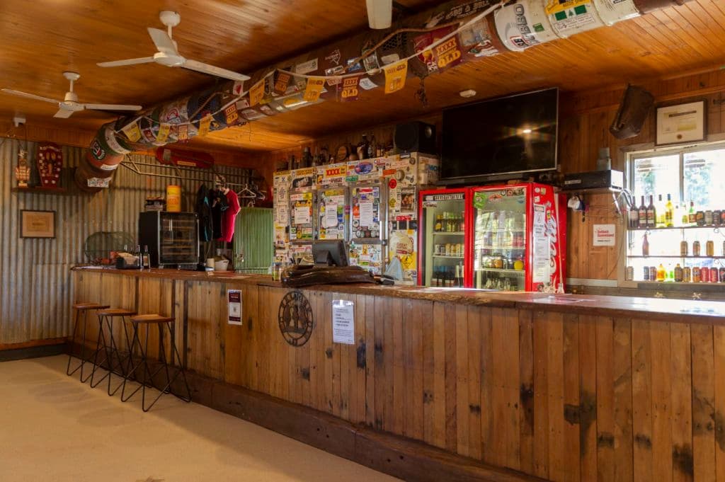 The public bar is decked out in timber, with XXXX stickers decorating the fridge.