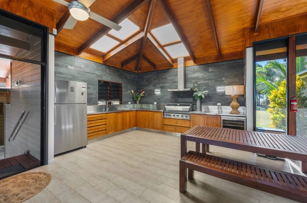 a kitchen with timber roof and fans.