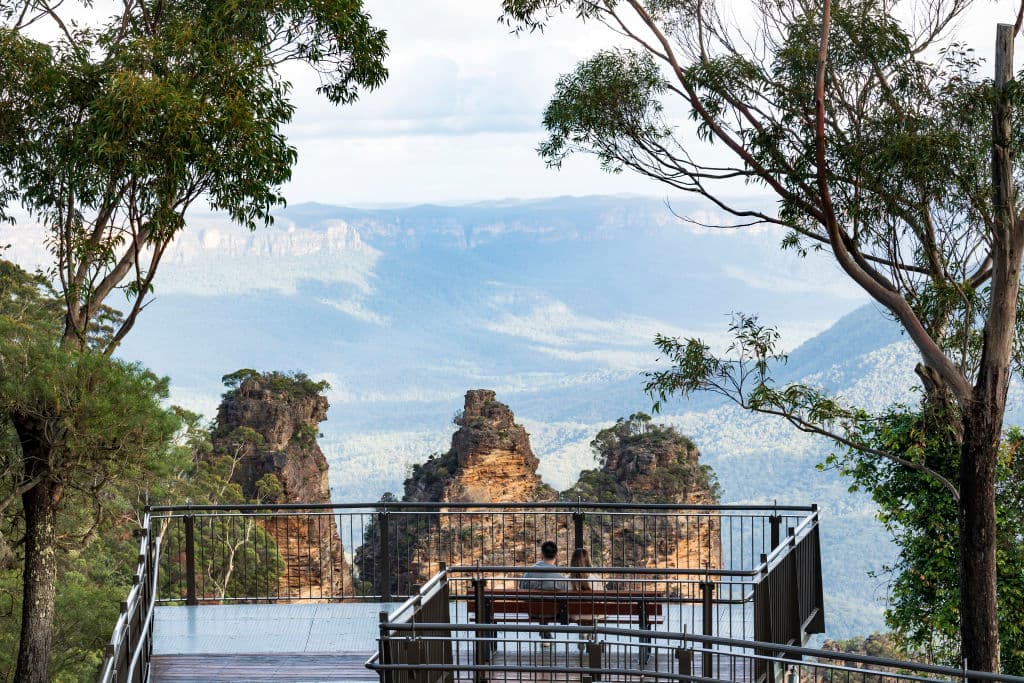 Couple enjoying the scenic views across the Jamison Valley from Echo Point Lookout in the Blue Mountains.