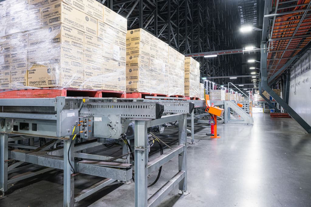 Pallets of McCains fries run along a conveyer belt inside the big fridge.